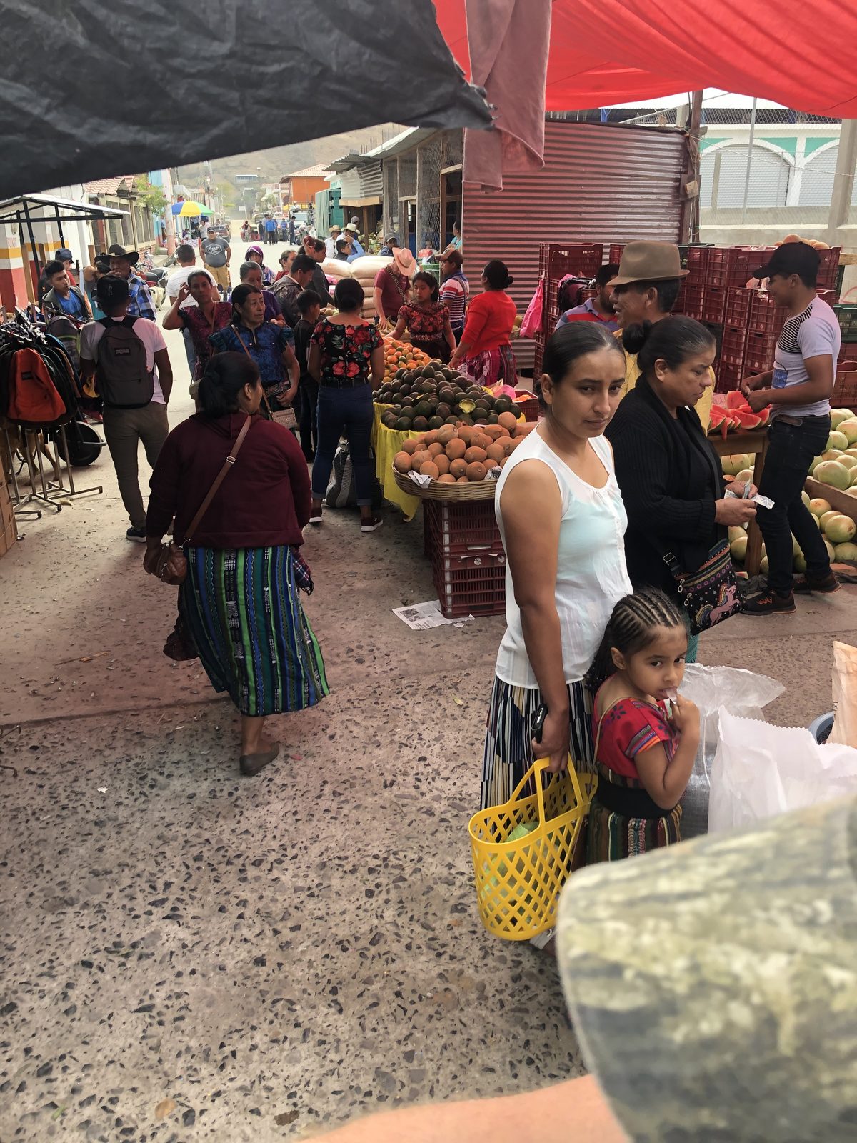 Market day in Canillá, Guatemala, with fruit vendors and families shopping